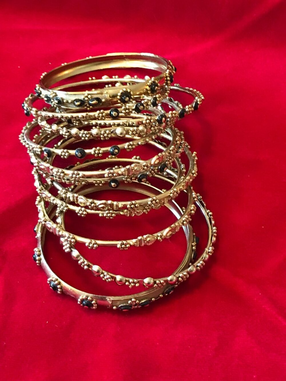 Stack of 12 Gold Tone and Black Metal Floral & Textured Bangles